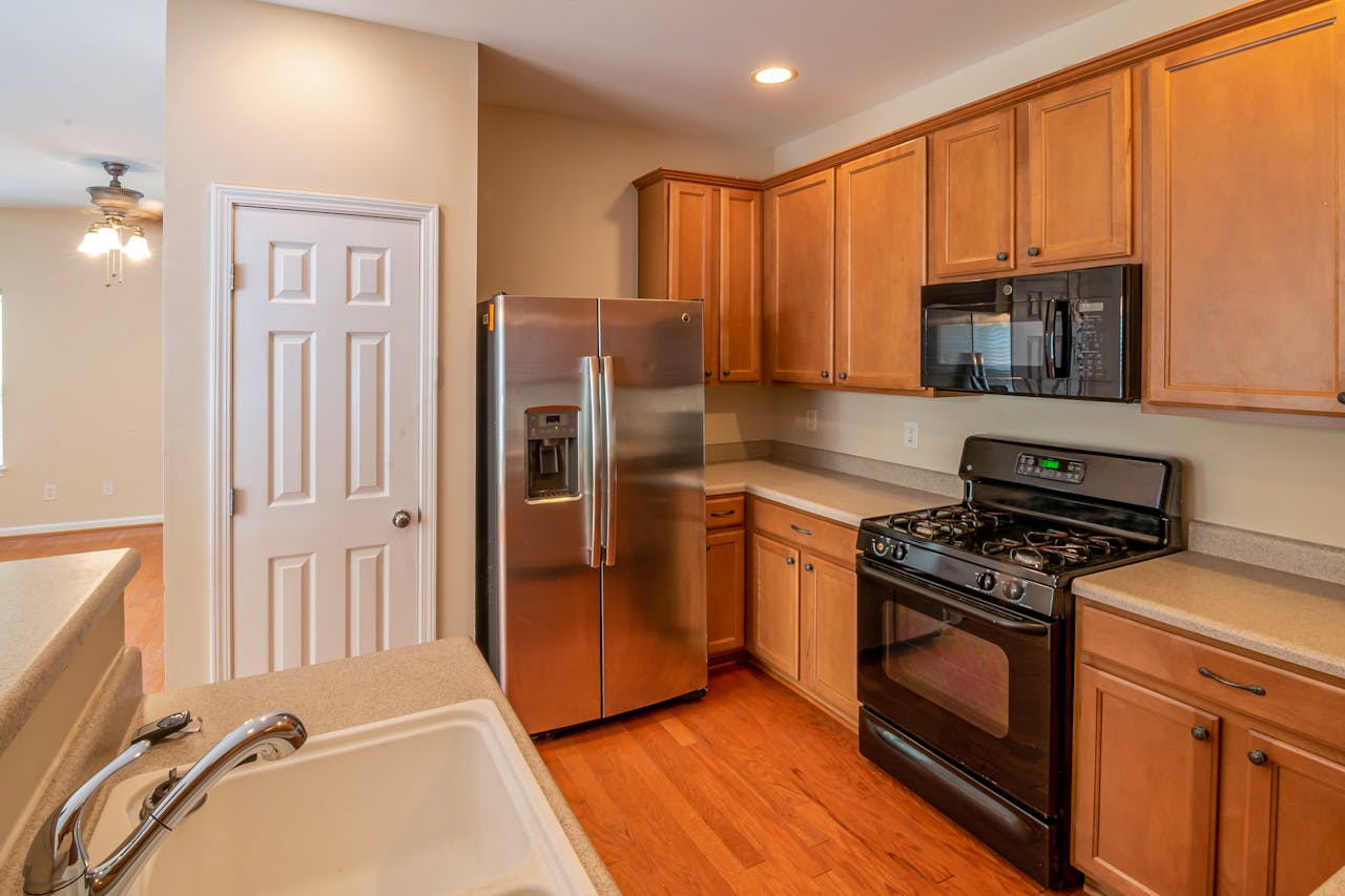 Contemporary kitchen featuring wooden cabinets, stainless steel refrigerator, and modern appliances.